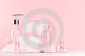 Gentle girlish dressing table with cosmetics products - rose oil, bath salt, cream, perfume, cotton towel, bottle and bowl.