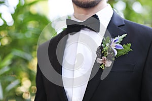 Gentle groom boutonniere with roses, chrysanthemum