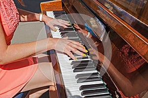 Gentle hands of girl pianist on the keys of instrument