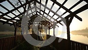 Gentle kiss of newlywed couple near beach shed at the evening of wedding day at the mountain resort lake on the sunset