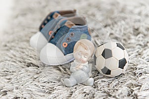 Gentle little newborn baby, a soccer ball and children`s sneaker