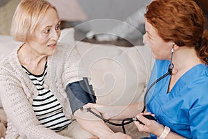 Gentle mindful nurse employing blood pressure sensor