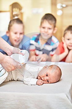 Gentle mother hands cover newborn baby with soft blanket