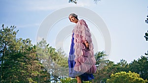 Gentle nymph posing nature in front green forest. Fascinate woman standing stone