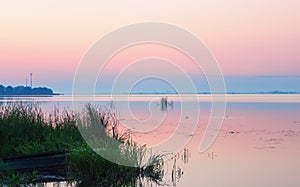 Gentle Pink Dawn Over the Blue Horizon of a Calm Lake