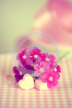 Gentle pink flower and heart on table.