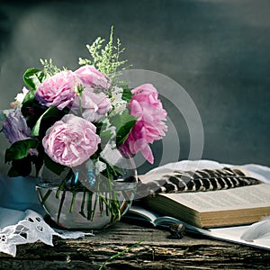 Gentle pink roses bouquet with old books on a old wooden background