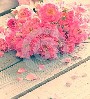 Gentle pink roses on wooden table