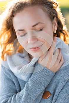 A gentle portrait of a girl with closed eyes enjoying the warm spring air