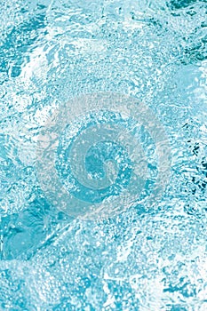 Gentle ripples and bubbles on a bright blue water surface create a serene and refreshing atmosphere