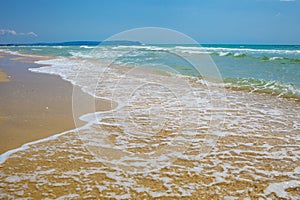 Gentle sea waves on a sandy beach, full frame nature background concept for tourism, vacations and environmental