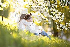 Gentle sisters hug apple blossom, sunny childhood