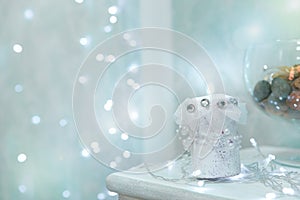Gentle sky blue Christmas background with bokeh and burning candle in the foreground. Christmas winter background. The
