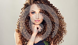 Young, brown haired woman with dense,elastic curls in a hairstyle. photo