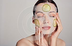 Gentle sophisticated calm girl in a moisturizing mask with a fresh cucumber on the face