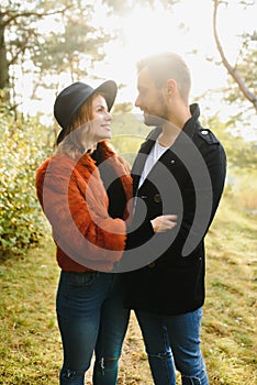 gentle and stylish couple are having a walk in the autumn park.