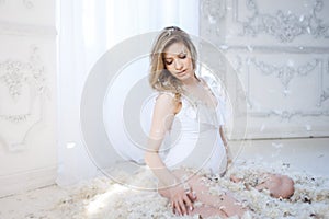 Gentle and sweet pregnant woman in the image of a mother bird in the nest, concept. Young blonde woman