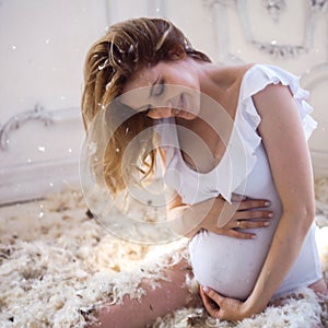 Gentle and sweet pregnant woman in the image of a mother bird in the nest, concept. Young blonde woman