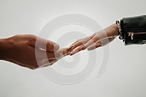 A gentle touch of the hands of a man and a woman on a white background. Love connection help concepts. Be hand in hand