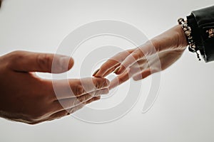 A gentle touch of the hands of a man and a woman on a white background. Love connection help concepts. Be hand in hand