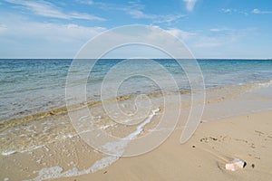 Gentle waves on an empty sandy beach with a calm ocean photo