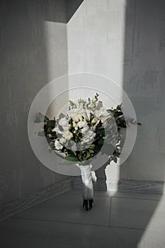 Gentle wedding bouquet of white roses and greenery, on a white background