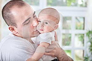 Gentle young father comforting crying baby