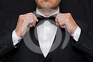 Gentleman in Black Tie Straightens His Bowtie