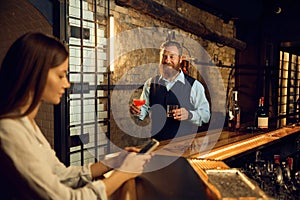 Gentleman courting loving woman bringing alcoholic beverage