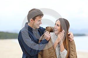 Gentleman covering his girlfriend with a jacket a cold day