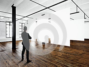 Gentleman Modern art museum expo loft interior.Open space studio.Empty white canvas hanging.Wood floor,bricks wall