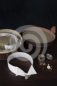 Gentleman\'s collar, collar studs, and leather collar box on a dark wood table