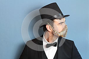 Gentleman in a tuxedo wearing golden face mask