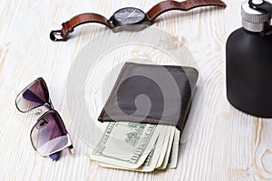 Gentlemanly set: sunglasses, perfume, wallet, watch on wooden background