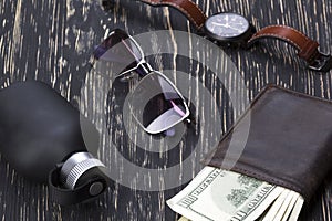 Gentlemanly set: sunglasses, perfume, wallet, watch on wooden background