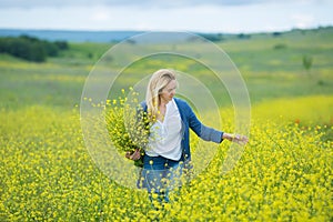 Genuine cute lady woman in meadow of yellow flowers sniffing flower bouquet. Attractive beautiful young girl enjoying the warm sum
