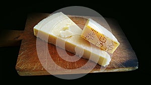 Genuine slice of parmigiano reggiano on the chopping board photo