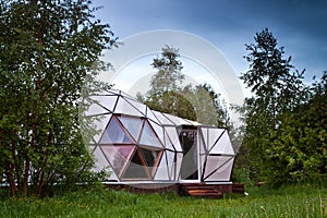 Geodesic dome in the forest, white house