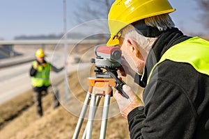 Geodesist measure land with tacheometer highway