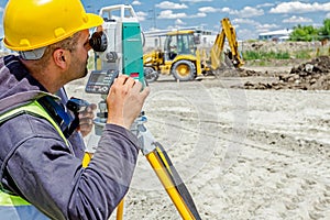 Geodesist is working with total station on a building site. Civil engineer with theodolite equipment during surveyor work.