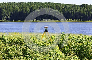 Geodetic GNSS receiver installed on the river bank works autonomously photo