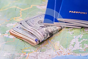 Geographic concept of vacation travel and spending money. Cash dollars and documents are on the world map. Selective focus. Money