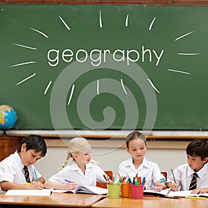 Geography against cute pupils sitting at desk