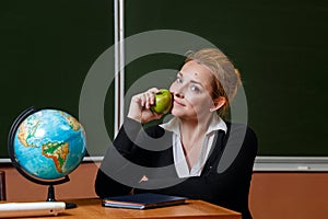 Geography teacher holding a green apple.