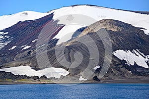 Geologic layers on volcanic mountains of Deception Island, Antarctica. Small sunken tanks of abandoned whale station, Lost places,