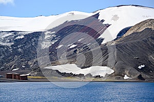 Geologic layers on volcanic mountains of Deception Island, Antarctica. Small sunken tanks of abandoned whale station, Lost places,