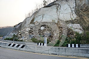 Geological erosion of shale sedimentary rock and mudstone layers along the roadside.