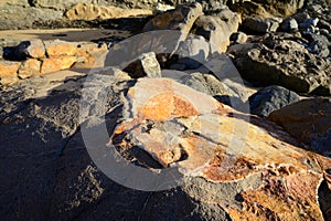 Geological formation of colorful stones with different layers, sand, fossil rocks on Magoito beach, Atlantic ocean coast near