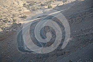 Geological landscape of Jabal Jais characterised by dry and rocky mountains, Road between mountains in Ras Al Khaimah, United Arab