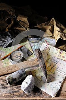 Geological tools - maps, hammer, notepad, geological compass, magnifying glass.